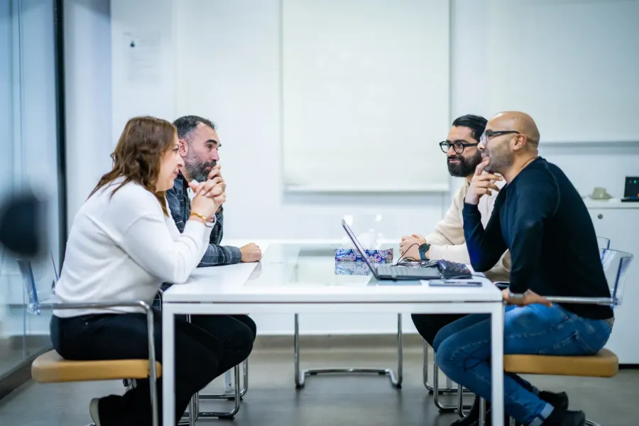 Quatre collaborateurs Outsourcia en réunion de travail autour d'une table